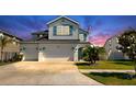 Charming two-story home featuring a three-car garage, landscaped yard, and crisp white exterior at 11625 Tetrafin Dr, Riverview, FL 33579