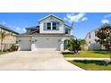 Charming two-story home featuring a three-car garage, landscaped yard, and crisp white exterior at 11625 Tetrafin Dr, Riverview, FL 33579