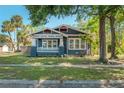 Charming craftsman home with mature trees, a lovely front porch, and inviting curb appeal at 121 W Mohawk Ave, Tampa, FL 33604