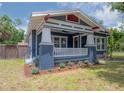 Charming craftsman-style home boasts blue siding, white trim, a welcoming front porch, and fresh landscaping at 121 W Mohawk Ave, Tampa, FL 33604