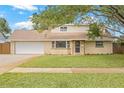Charming home with a brick-accented front, a well-manicured lawn, and an attached two-car garage at 15034 Newport Rd, Clearwater, FL 33764