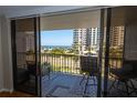 Balcony view featuring two chairs overlooking the ocean with palm trees and high-rise buildings at 1581 Gulf Blvd # 301N, Clearwater Beach, FL 33767