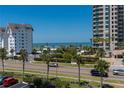 Scenic street view of lush landscaping across the street from the beautiful beach at 1581 Gulf Blvd # 301N, Clearwater Beach, FL 33767