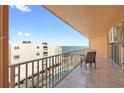 A view from the tiled balcony highlighting a table, chairs, and ocean view at 16400 Gulf Blvd # 505, North Redington Beach, FL 33708