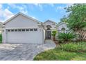 Charming single-story home featuring manicured landscaping and a spacious two-car garage, enhancing its curb appeal at 18836 Maisons Dr, Lutz, FL 33558