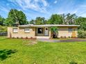 Inviting single-story brick home with a well-kept lawn, pretty landscaping, and a bright white front door at 2054 Deerwood Rd, Seffner, FL 33584