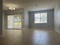 Spacious living room with tile flooring, neutral paint, sliding door to balcony, and window with bright, natural light at 2333 Feather Sound Dr # B104, Clearwater, FL 33762