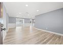 Expansive living room boasting recessed lighting, fresh paint, wainscoting, and attractive wood-look floors at 2616 Ohio Pl, Holiday, FL 34691