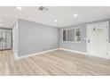 Bright living room with wood-look floors, fresh paint, and a window providing natural light at 2616 Ohio Pl, Holiday, FL 34691