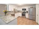 Modern kitchen with stainless steel appliances, granite countertops, and ample cabinet space at 3422 Trask Dr, Holiday, FL 34691