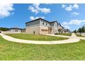 View of a well-maintained two-story home with a lush green lawn and attached garage at 34780 Rainville Loop, Zephyrhills, FL 33541