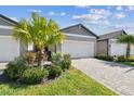 Inviting home features a lush, manicured lawn and a pristine two-car garage with paver driveway at 3764 Laughing Dove Ave, Sun City Center, FL 33573