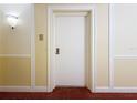 Hallway entrance features a solid white door, plush carpeting, and decorative wall trim at 4900 Brittany S Dr # 211, St Petersburg, FL 33715