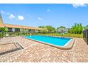 Community swimming pool, surrounded by brick patio, offers a relaxing outdoor space at 4991 Puritan Cir # 522, Tampa, FL 33617
