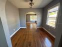 Dining room boasts shiny hardwood floors, arched doorway, and natural light from a large window, creating an inviting space at 536 89Th N Ave, St Petersburg, FL 33702