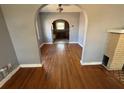 Open-concept living room with hardwood floors, arched openings, and a fireplace, perfect for gatherings at 536 89Th N Ave, St Petersburg, FL 33702