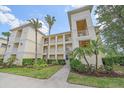 A well-maintained condo building with manicured landscaping and palm trees at 600 Gardens Edge Dr # 614, Venice, FL 34285