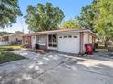 Brick home featuring a well-kept front yard, driveway, and an attached single-car garage at 705 E Alabama St, Plant City, FL 33563