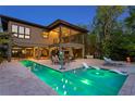 Backyard featuring a modern pool, sun loungers, an outdoor dining area, and lush landscaping at 7508 N Ola Ave, Tampa, FL 33604