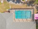 A lovely aerial view of a sparkling in-ground pool enclosed within a screened lanai at 7660 Holiday Dr, Spring Hill, FL 34606