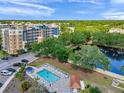 Aerial shot of the neighborhood pool offering lounge chairs and lush tropical landscaping at 960 Starkey Rd # 1503, Largo, FL 33771