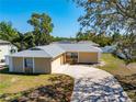 Inviting single-Gathering home featuring a two-car garage, complemented by mature landscaping at 14136 Payne St, Spring Hill, FL 34609