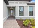 Inviting front entrance with a paved walkway leading to a modern glass door at 17200 Luminous Ave, Venice, FL 34293