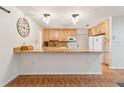 Open kitchen featuring wooden cabinets, granite countertops, and modern lighting at 22465 Lewiston Ave, Port Charlotte, FL 33952
