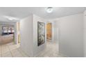 Bright hallway featuring neutral tile flooring and walls and with a decorative painting at 2693 Sabal Springs Cir # 201, Clearwater, FL 33761
