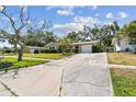 A cozy home with a well-maintained driveway and mature trees, providing ample shade and curb appeal at 3072 Keene Park Dr, Largo, FL 33771