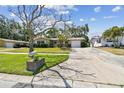 A well-manicured lawn and mature trees surround this cozy single-story home, enhancing its curb appeal at 3072 Keene Park Dr, Largo, FL 33771