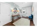 Inviting foyer with a table and a round mirror, leading to a staircase with dark treads at 310 S Habana Ave # 5, Tampa, FL 33609