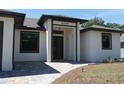 Inviting entrance with a covered porch featuring modern design elements and paver walkway at 3125 Tucson Rd, North Port, FL 34286