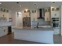 Modern kitchen featuring stainless steel appliances, a large island, and stylish pendant lighting at 3125 Tucson Rd, North Port, FL 34286