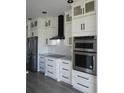 Bright kitchen showcases white cabinets, stainless steel appliances, and a modern backsplash at 3125 Tucson Rd, North Port, FL 34286