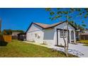 Exterior view of a well-kept home showcasing its side yard and screened-in porch area at 3145 Munson St, New Port Richey, FL 34655