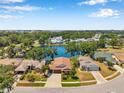 Stunning aerial view of a home nestled by a serene lake surrounded by lush trees and well-manicured lawns at 3610 Montero Ct, Sun City Center, FL 33573