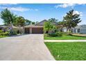 Charming home featuring a brick-accented facade, a spacious three-car garage, and a beautifully landscaped front yard at 3610 Montero Ct, Sun City Center, FL 33573
