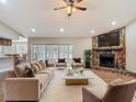 Spacious living room with a stone fireplace, ceiling fan, neutral decor, and lots of natural light at 3810 Hollister Pl, Brandon, FL 33511