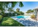 Serene backyard pool area surrounded by vibrant greenery and a paved patio, perfect for relaxation at 4104 W Watrous Ave, Tampa, FL 33629