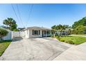 Bright exterior showcases an ample driveway, manicured lawn, and classic architecture against a clear blue sky at 4104 W Watrous Ave, Tampa, FL 33629