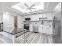 Bright kitchen features stainless steel appliances, white cabinets, and stone countertops at 4137 Northmeadow Cir, Tampa, FL 33618