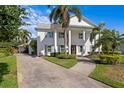 Two-story home featuring a classic facade with stately columns, mature palm trees, and walkway at 4935 W Bay Way Pl, Tampa, FL 33629