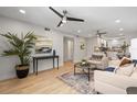 Bright living room featuring modern decor, wood floors, and an open layout leading to the kitchen at 506 71St Ave # 7, St Pete Beach, FL 33706