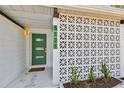 Welcoming front entryway showcasing a modern green door, decorative cinder block and plants at 5121 Flamingo N Dr, St Petersburg, FL 33714