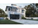 Modern home exterior showcasing a sleek design, dark garage door, and a spacious driveway at 5406 N Pershing Pl, Tampa, FL 33603
