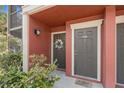 Close-up of a condo doorway with muted terra cotta exterior and welcoming floral wreath at 5636 Baywater Dr # 5636, Tampa, FL 33615