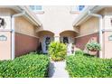 Charming townhome entrance with lush landscaping and decorative flower arrangements at 6303 Vista Verde E Dr, Gulfport, FL 33707