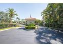 View of the gated entrance featuring an American flag and tropical landscaping at 6303 Vista Verde E Dr, Gulfport, FL 33707