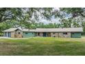 Charming single-story house with stone accents, green siding, and a meticulously maintained lawn at 6702 Towhe Dr, Seffner, FL 33584